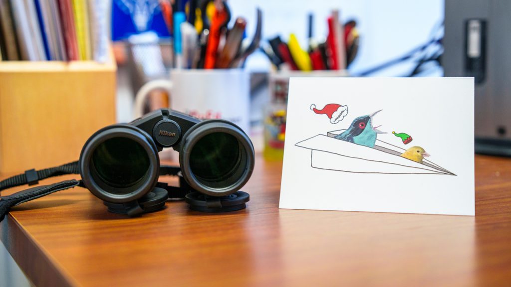 A pair of binoculars and a holiday card on a table