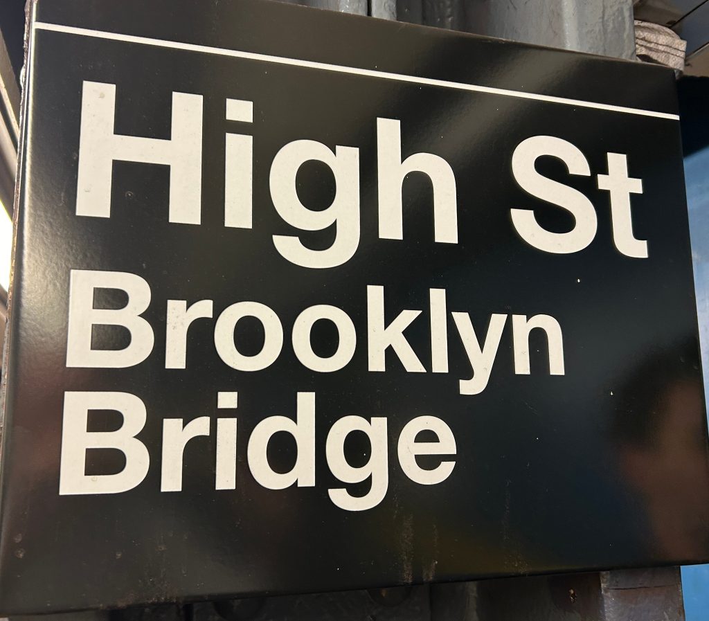 An image of a New York City subway sign printed in Helvetica 