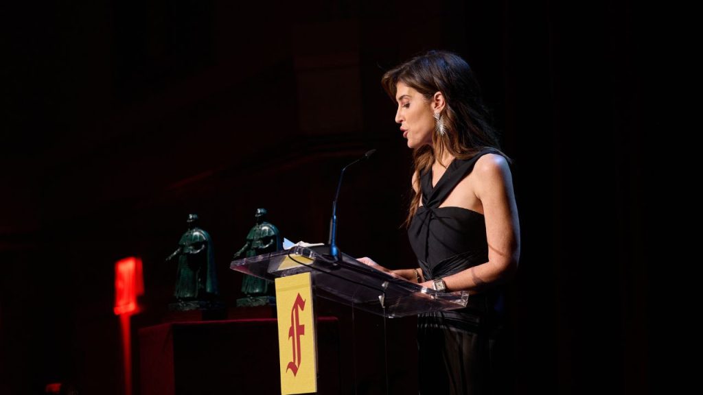 Women in black halter dress at podium
