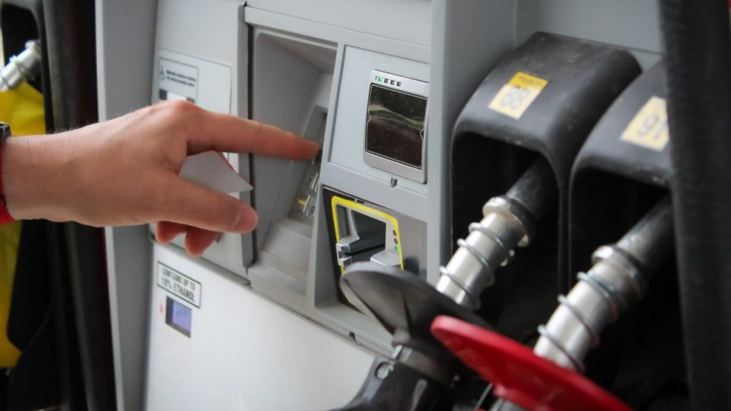 A photo of a person pressing buttons at a gas pump, representing gas prices rising amid the war on Iran