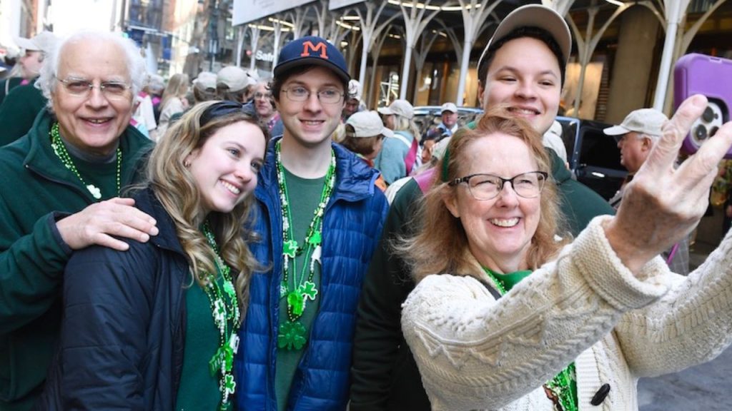 A group of people take a selfie at the St. Patrick's Day parade in NYC, representing Fordham's Irish roots.