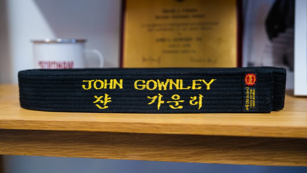 A black belt that says "John Gownley" and his name in Korean