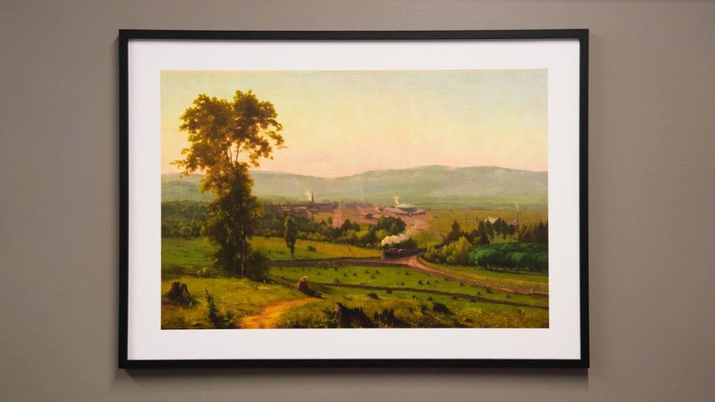 A framed photo of a landscape hanging on a wall
