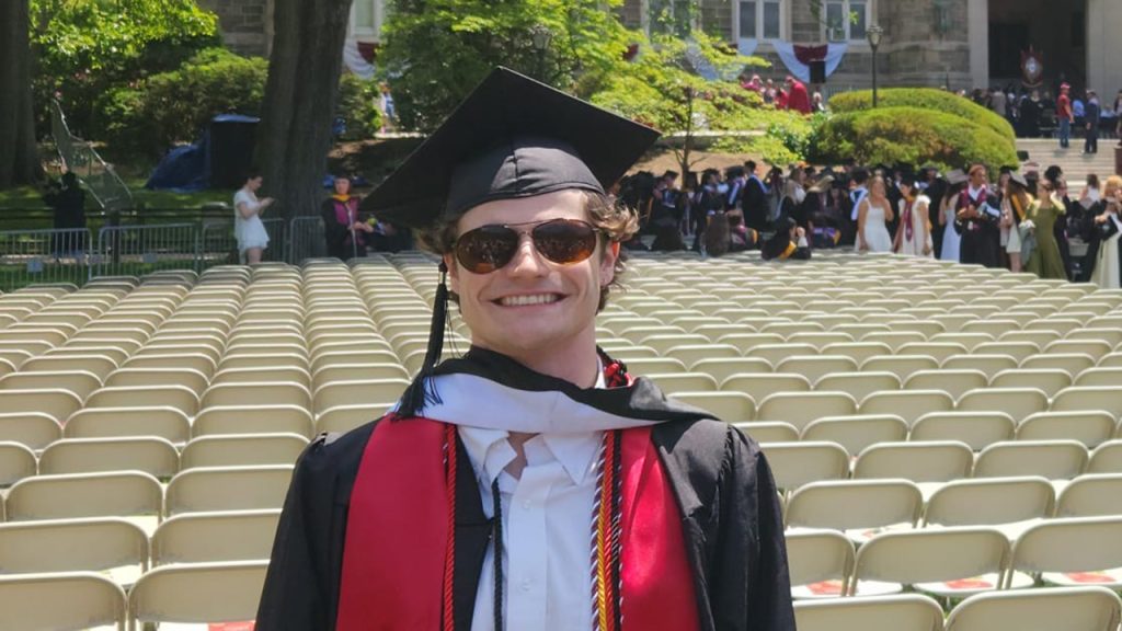 Aaron Boyd smiling at the camera on Edwards Parade on graduation day