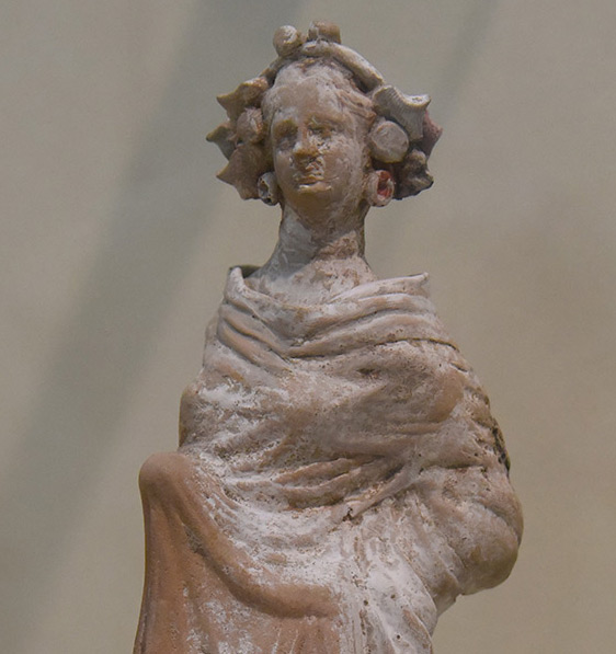 Figurine representing a woman wearing a crown of grape leaves and grapes, marking her as a follower of Dionysius, god of fruitfulness, wine, and ecstasy