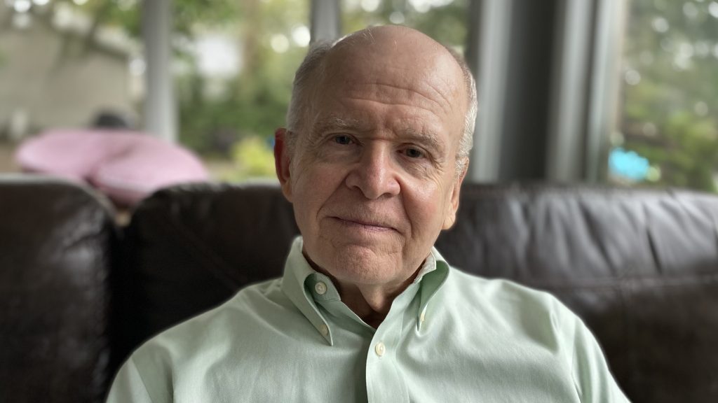 Terrence Quinn seated on brown couch