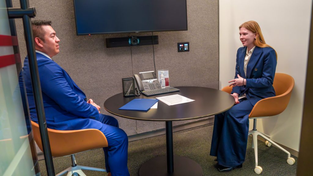No Job After Graduation? Strategic Steps to Find Your Path A man in a blue suit sits across the table from a young woman in a blue suit during a mock interview event at Fordham's Career Center