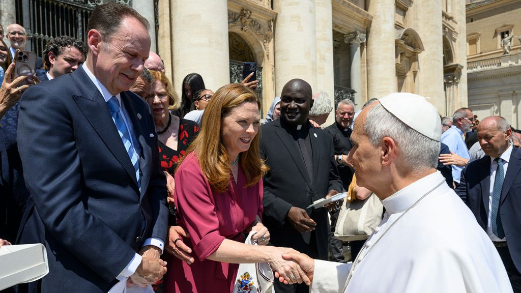 Men and women greet and shake hands with Pope Leo at the Vatican.
