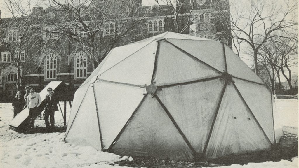 Barbara Tomaskovic-Devey, Donald Tomaskovic-Devey, John Fontanetta, and Jim McGurk standing next to the geodesic dome built on the Rose Hill campus, with Keating Hall in the background.