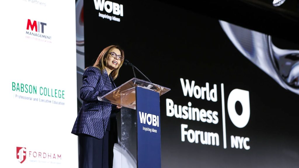 Lerzan Aksoy, dean of Fordham’s Gabelli School of Business, speaking at a podium during the World Business Forum NYC.