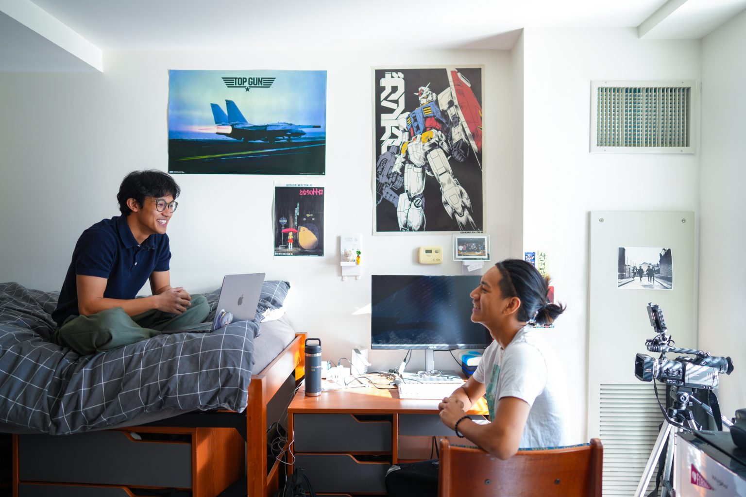 Dorm Packing List: What to Bring for College Move-In Two boys chat in a dorm room with posters on the wall