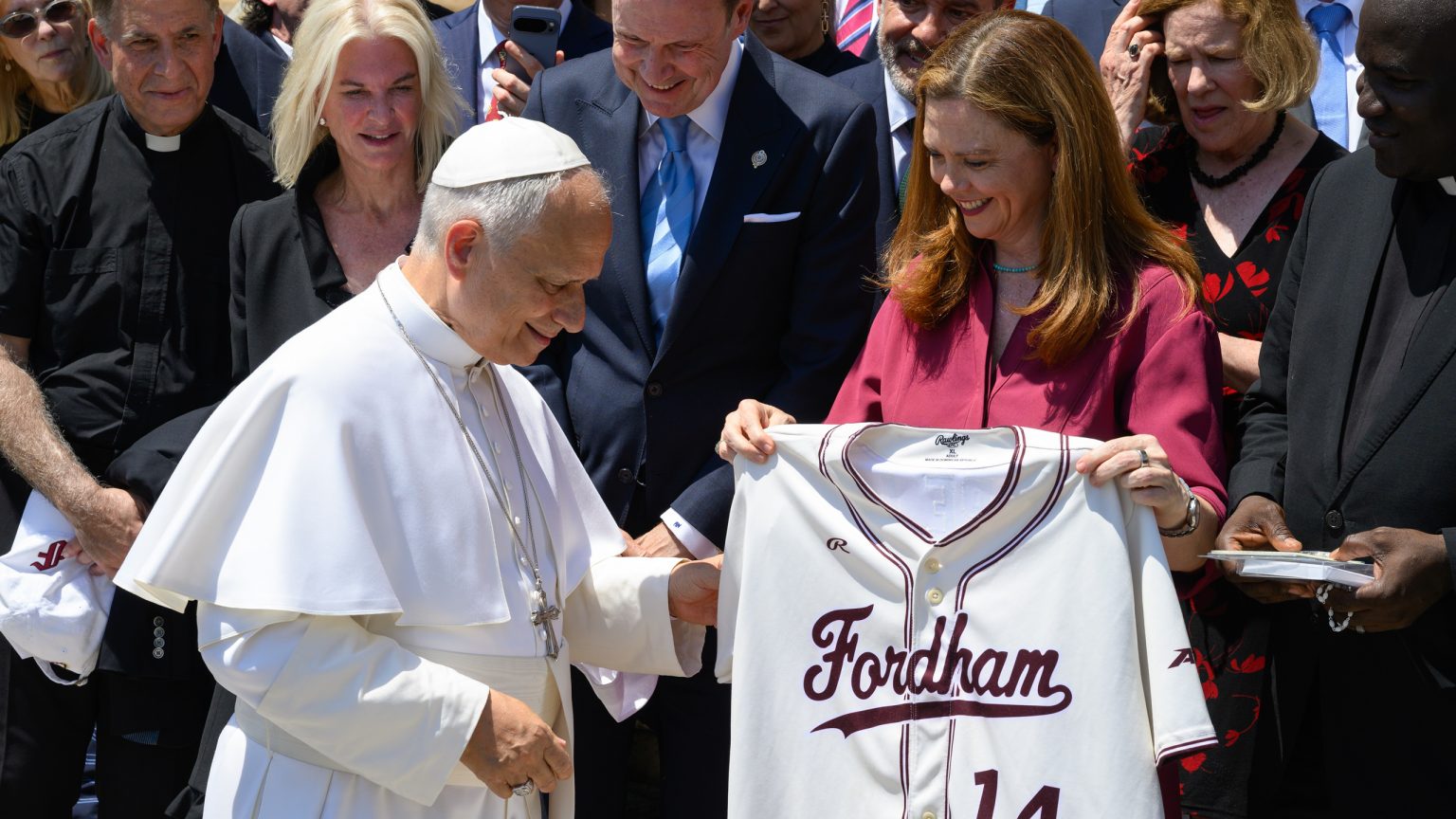 President Tetlow presents the pope with a custom white Fordham jersey.