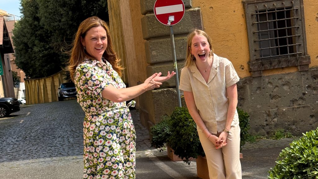 President Tetlow happily gestures toward a student who looks happy and shocked.