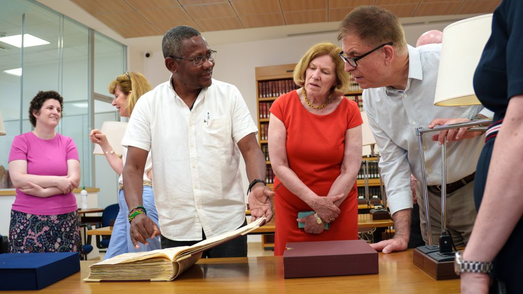 Festo Mkenda, SJ, shows the Fordham delegation an ancient book.