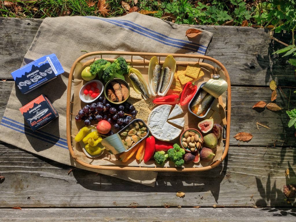 A spread of food that includes Patagonia Provisions tinned fish and crackers.