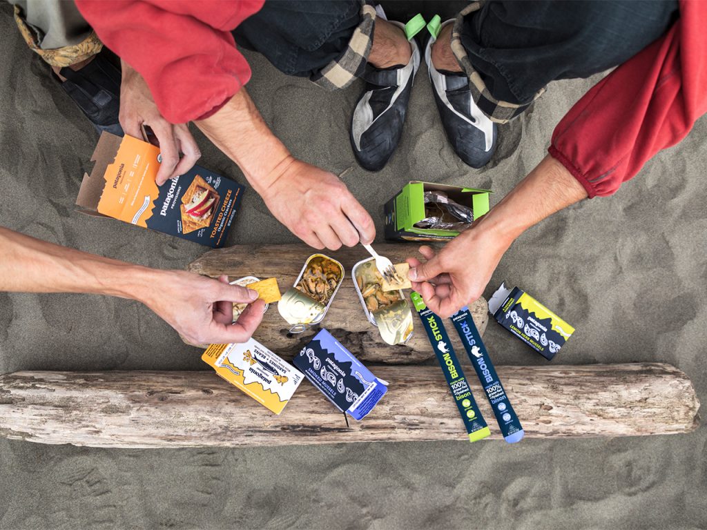 Arms reaching to put Patagonia Provisions tinned fish on crackers.