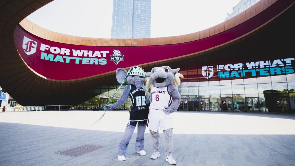 Fordham Teams Up with the New York Liberty A photo of an elephant mascot and a ram mascot in front of Fordham branding at the Barclays center representing Fordham's partnership with the New York Liberty