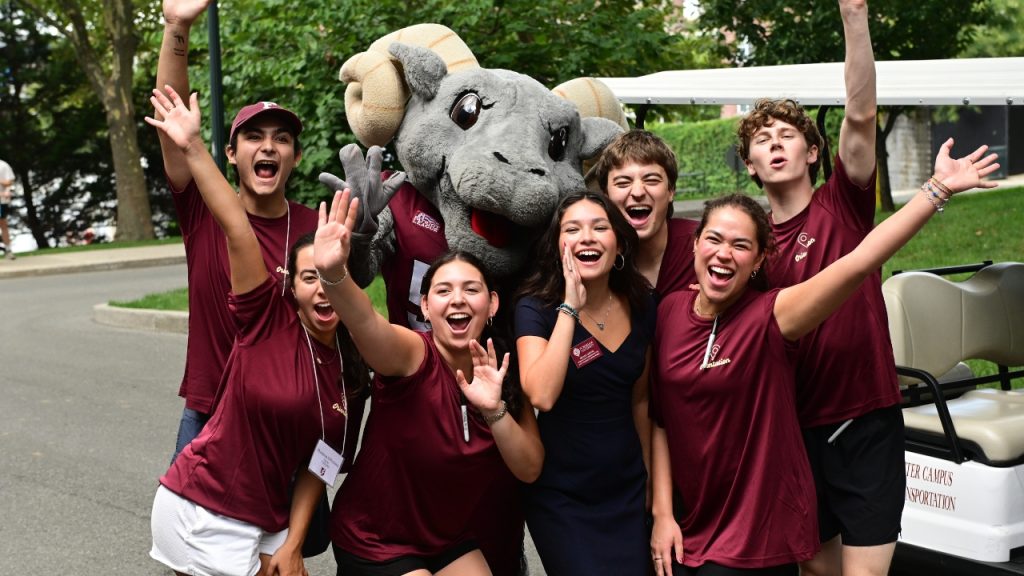 10 Things to Know About Opening Day A group of young adults in maroon shirts pose with Ramses during Fordham's Opening Day
