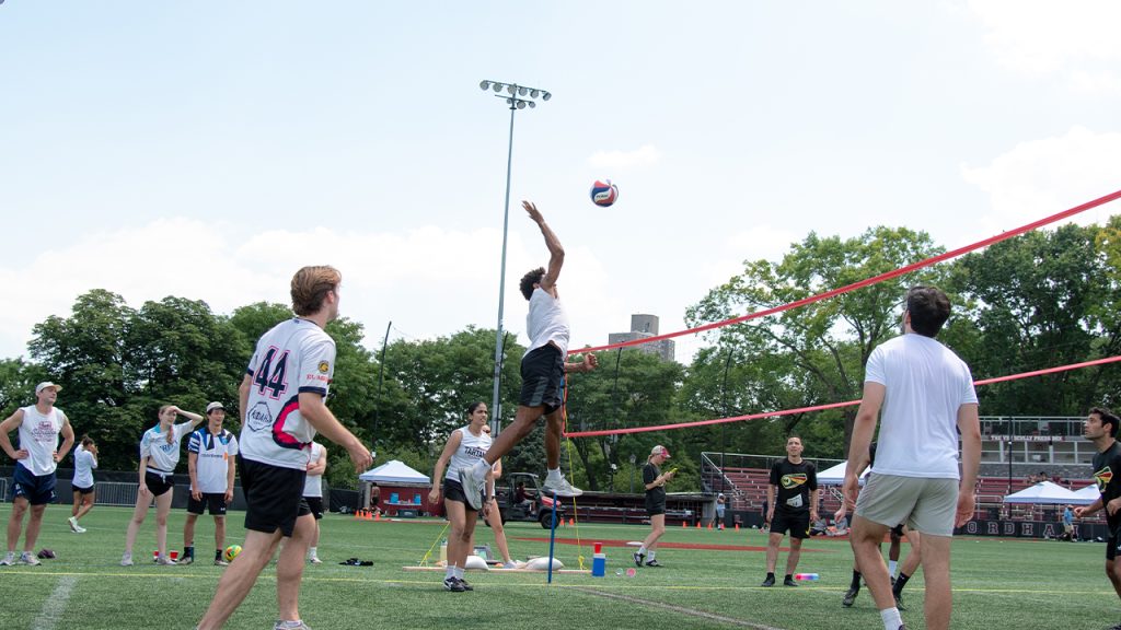 A volleyball player hitting the ball over the net