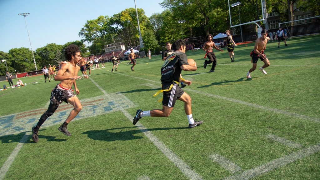 A player running with the football as defenders try to catch him