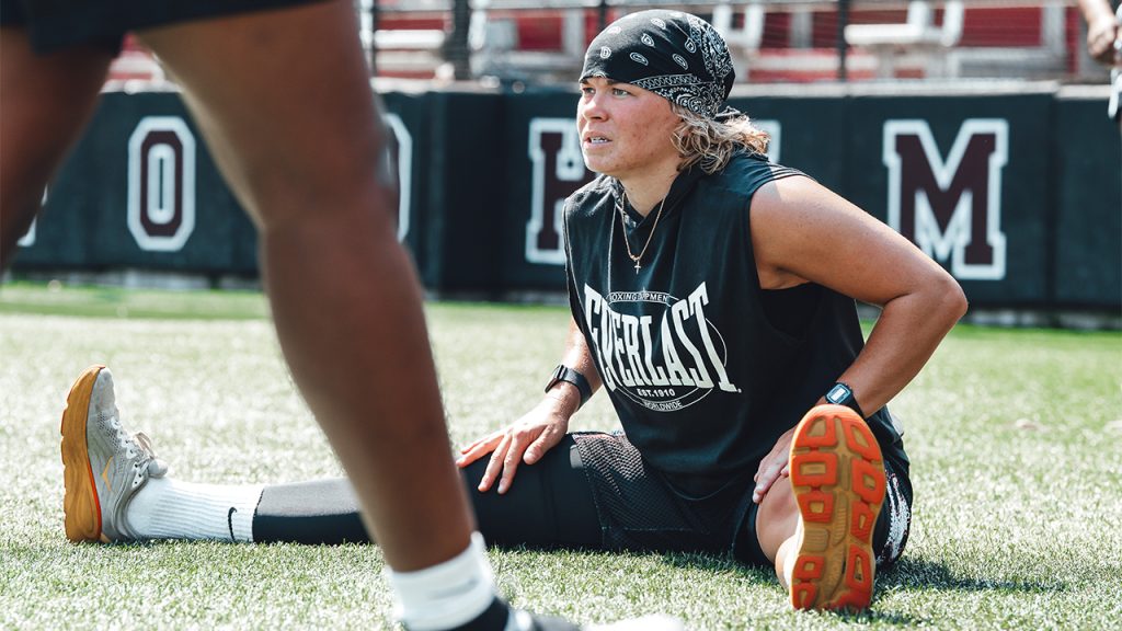 A participant stretching their legs on the field