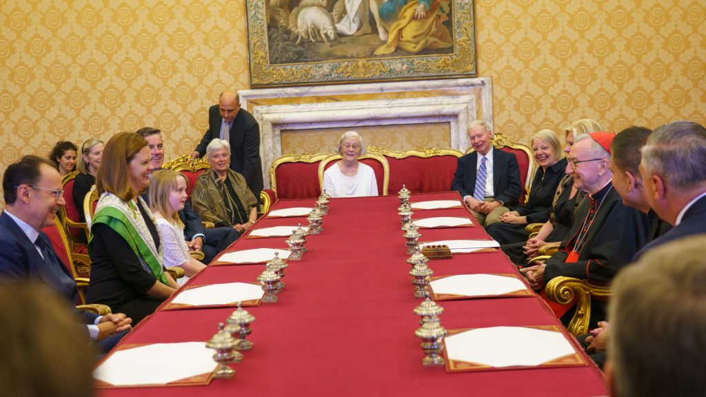 A group of people meet around a big table.
