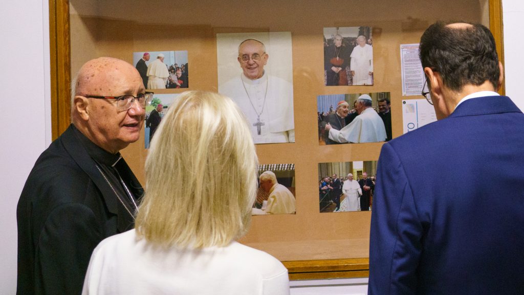 A group of people gather around a bulletin board.