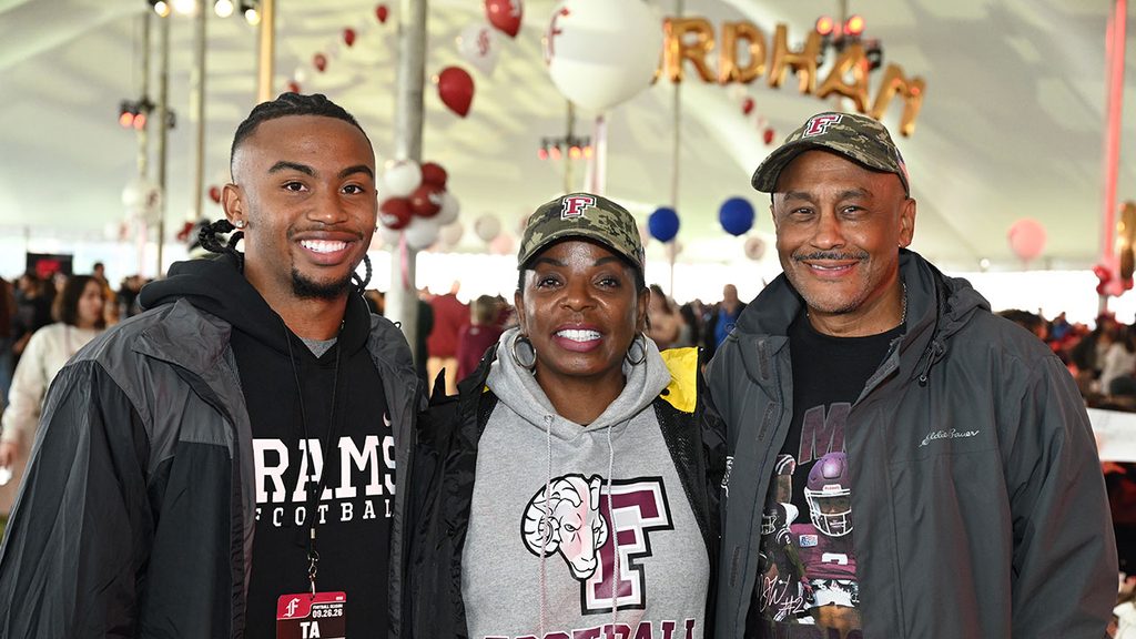 Black family wearing Fordham gear inside tent