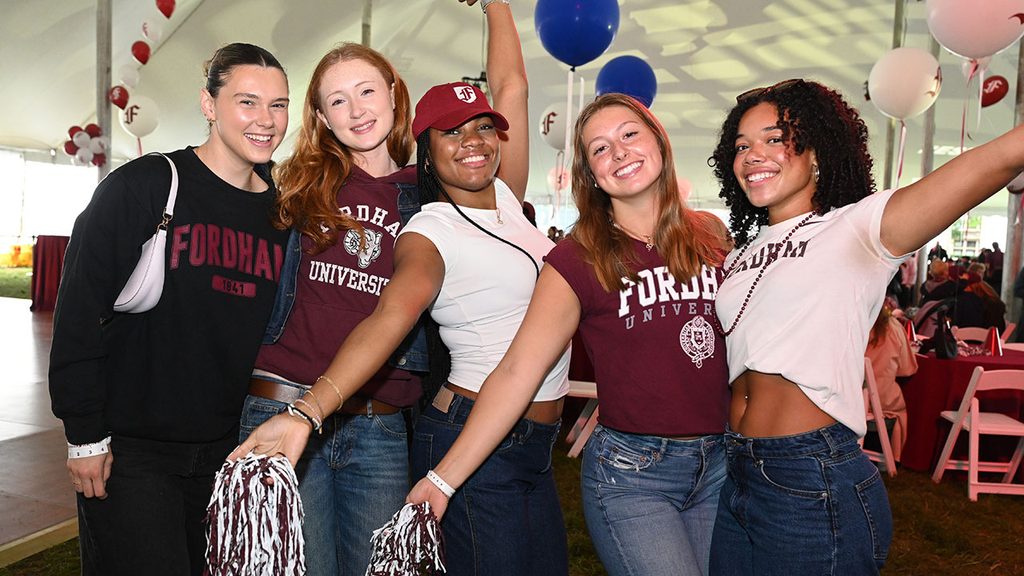 college students with pom poms celebrating Homecoming