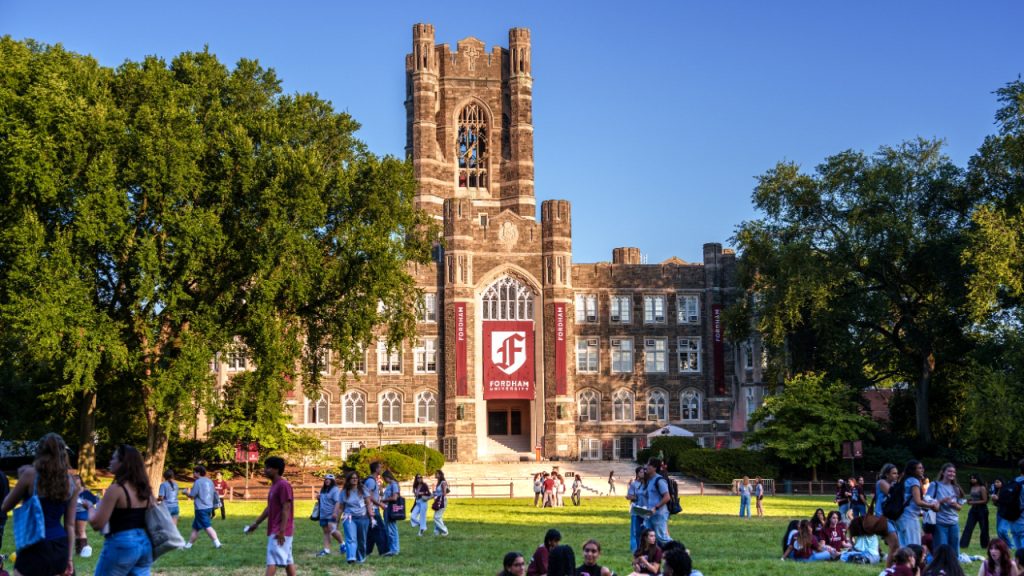 Fordham Rises in U.S. News Rankings A photo of Fordham's Keating Hall with banners featuring the new logo