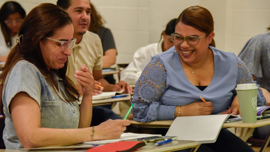 Two adult students working together in a classroom