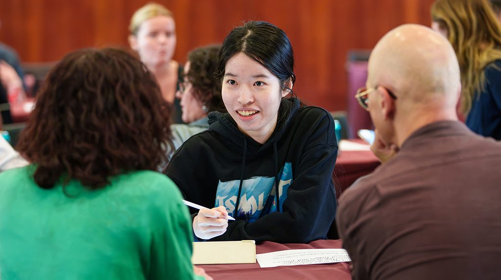 A Fordham student speaking with faculty researchers at the transdisciplinary research fair